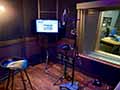 Vocal setup in an isolation booth adjacent to the Crimson Room at s5studio in Manhattan, with the control room visible through the glass, featuring Genelec 8331A Smart Active Monitors™ as near-fields and two Genelec 1234A Smart Active Monitors as the mains